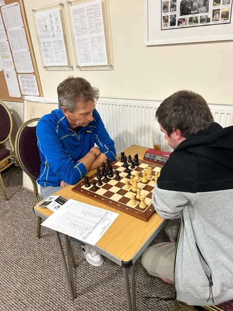 Two players at board 1 with the clock showing about fifteen minutes each